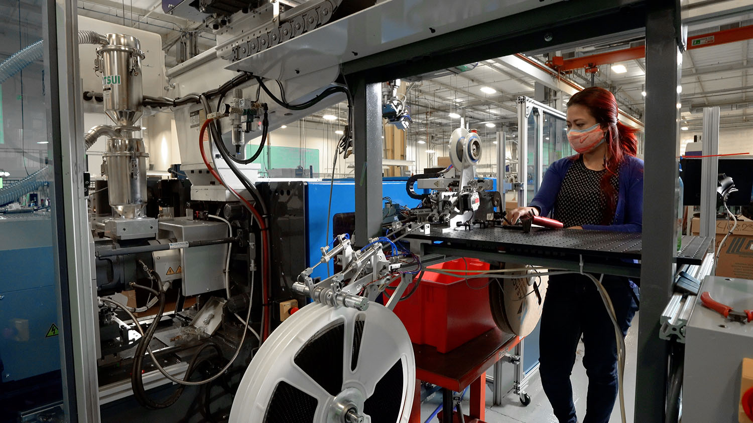 US Digital Mechanical Engineer Camilla Garcia works a new machine she designed in the injection molding area.
